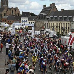 El pelotón circula bajo banderines decorativos colgados sobre el recorrido de la carrera en Aire-sur-la-Lys durante la tercera etapa de la 112ª edición del Tour de Francia, 178,3 km entre Valenciennes y Dunkerque (Dunkerque), en el norte de Francia. | Foto:afp