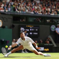 El serbio Novak Djokovic devuelve un golpe de derecha al australiano Alex De Minaur durante su partido de tenis de cuarta ronda individual masculino en el octavo día del Campeonato de Wimbledon 2025 en el All England Lawn Tennis and Croquet Club en Wimbledon, al suroeste de Londres. | Foto:afp