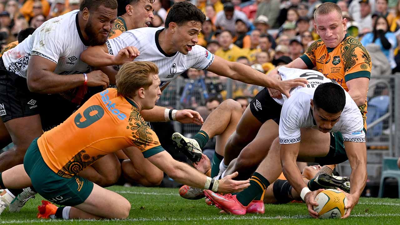 Max Jorgensen (der.) de Australia no logra evitar que Salesi Rayasi (2.º d.) de Fiji marque un try durante el partido de prueba de rugby entre Australia y Fiji en el estadio McDonald Jones en Newcastle | Foto:afp