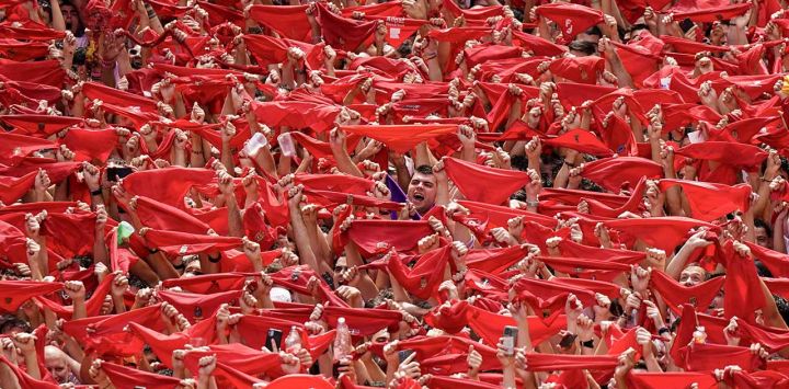 Los participantes ondean sus pañuelos rojos durante el 