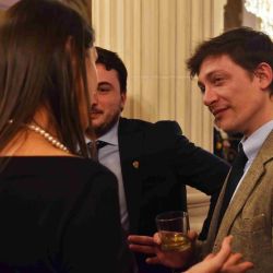 (Left to right): Macarena Alifraco, Agustín Romo and Santiago Caputo; (Back to camera) Unidentified guest. Photo taken at US Embassy Independence Day party in 2025.