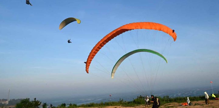 turistas disfrutando del parapente, en la ciudad de Rongcheng, en la provincia de Shandong, en el este de China. Con la llegada de las vacaciones de verano, muchos lugares de China han entrado en la temporada alta de turismo. (Xinhua/Yang Zhili)