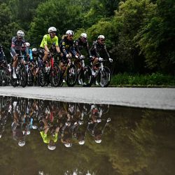 El pelotón se refleja en un charco mientras pedalean poco después del inicio de la tercera etapa de la 112.ª edición del Tour de Francia, una carrera ciclista de 178,3 km entre Valenciennes y Dunkerque (norte de Francia). | Foto:LOIC VENANCE / AFP