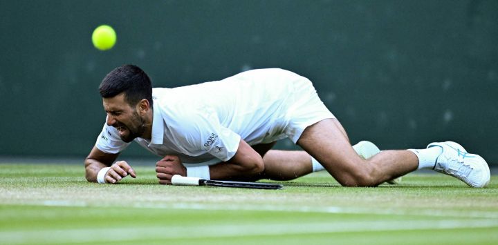 El serbio Novak Djokovic cae mientras juega contra el italiano Flavio Cobolli durante su partido de cuartos de final de tenis individual masculino en el décimo día del Campeonato de Wimbledon 2025 en el All England Lawn Tennis and Croquet Club en Wimbledon, al suroeste de Londres.