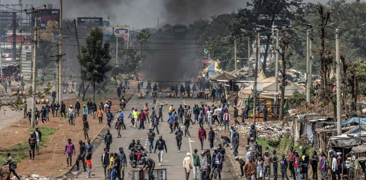 Manifestantes se congregan para bloquear una carretera principal con barricadas incendiadas y escombros urbanos durante los enfrentamientos en las manifestaciones del Día de Saba Saba en Nairobi, Kenia.