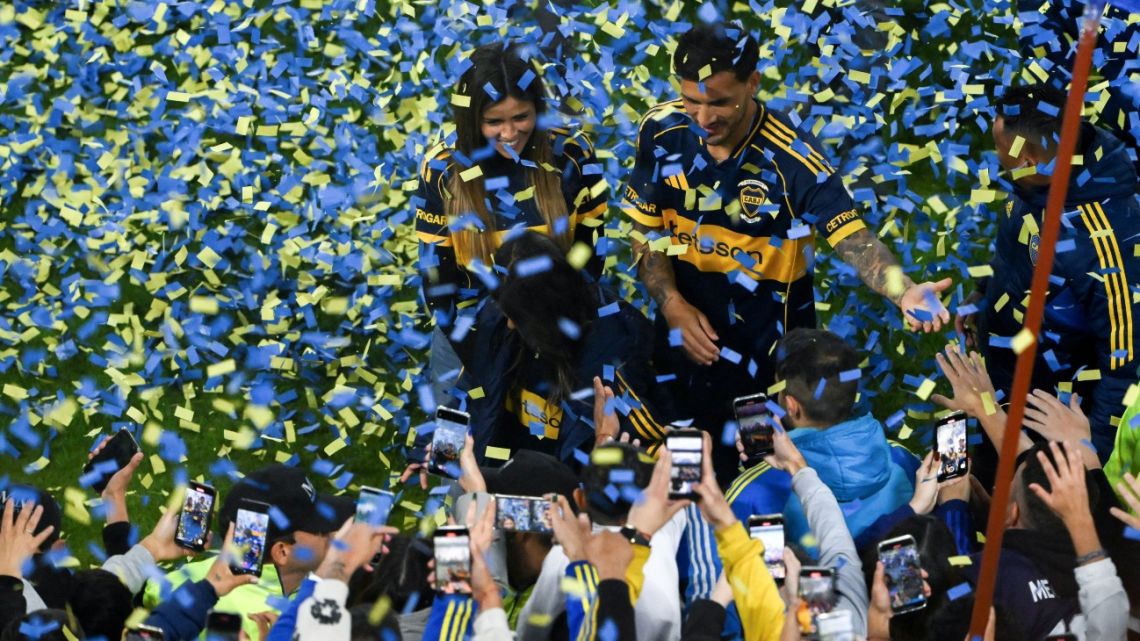 Argentina's Boca Juniors midfielder Leandro Paredes (2nd R) greets supporters next to his wife, Camila Galante, during his presentation at La Bombonera Stadium in Buenos Aires on July 10, 2025. Argentine midfielder Leandro Paredes, World Cup champion in Qatar 2022, returned to Boca Juniors, the team where he began his career between 2010 and 2013, before embarking on a European tour that culminated weeks ago at AS Roma. 