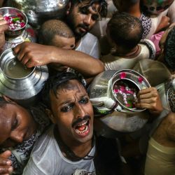 Devotos hindúes, portando vasijas llenas de agua bendita del río Ganges, entonan himnos mientras esperan para adorar al dios hindú Shiva en el templo de Kedareshwar en Varanasi, India. | Foto:NIHARIKA KULKARNI / AFP
