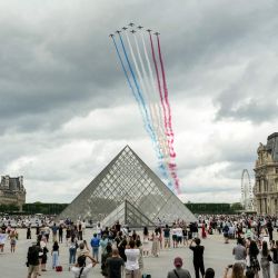 El equipo acrobático de élite de la Fuerza Aérea Francesa, "Patrouille de France" (PAF), lanza estelas con los colores nacionales de Francia durante un vuelo durante el desfile militar anual del Día de la Bastilla sobre la Pirámide del Louvre, diseñada por el arquitecto chino-estadounidense Ieoh Ming Pei, en París. | Foto:DIMITAR DILKOFF / AFP