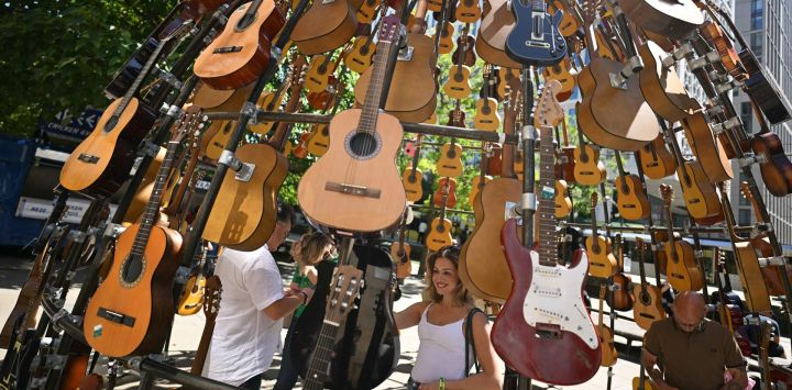 Personas posan para fotografías con la instalación artística "Catedral del Sonido" de Lazerian, en Manchester, norte de Inglaterra, antes de la segunda etapa de la esperadísima gira de reunión de la banda de rock británica Oasis.