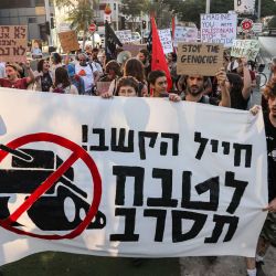 Activistas israelíes de izquierda marchan con pancartas y carteles durante una protesta contra la guerra en Gaza y llaman a rechazar el servicio militar en Tel Aviv. | Foto:AHMAD GHARABLI / AFP