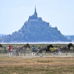 Caballos cabalgan por el hipódromo de Genet, con el Mont-Saint-Michel al fondo, para celebrar su 130.º aniversario, en Genet, noroeste de Francia. | Foto:LOU BENOIST / AFP