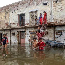 Residentes se reúnen frente a sus casas, sumergidas por las inundaciones tras las fuertes lluvias monzónicas en Hyderabad, provincia de Sindh. Las lluvias monzónicas en Pakistán se han relacionado con más de 110 muertes, incluidas decenas de niños, desde su llegada a finales de junio, según cifras gubernamentales. | Foto:Husnain Ali / AFP