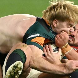 Ronan Kelleher (der.) de los British and Irish Lions tacklea a Harry McLaughlin-Phillips de Australia and New Zealand Invitational XV durante un partido de la gira. | Foto:William West / AFP