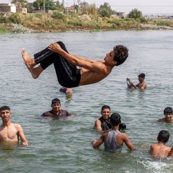 Un joven se sumerge en el río Éufrates para refrescarse durante los cortes de electricidad provocados por una ola de calor extrema en el distrito de Mishkhab, al sur de la ciudad de Nayaf, en el centro de Irak. | Foto:Qassem al-Kaabi / AFP