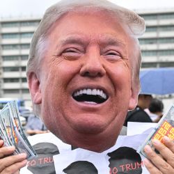 Un miembro de un grupo cívico con una máscara del presidente estadounidense Donald Trump se presenta durante una protesta contra la política arancelaria de Trump cerca de la embajada de Estados Unidos en Seúl. | Foto:Jung Yeon-je / AFP