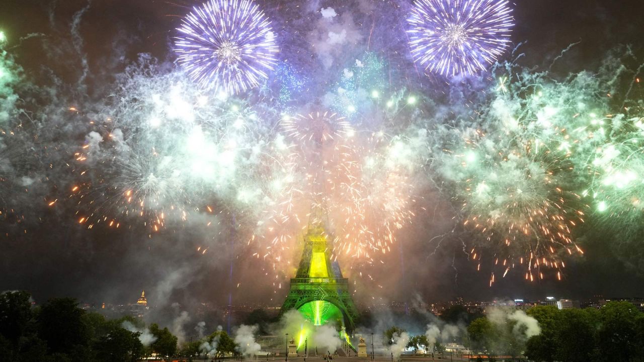 Los fuegos artificiales se encienden alrededor de la Torre Eiffel durante un espectáculo coreografiado de fuegos artificiales y drones para celebrar el Día de la Bastilla, en París. | Foto:DIMITAR DILKOFF / AFP