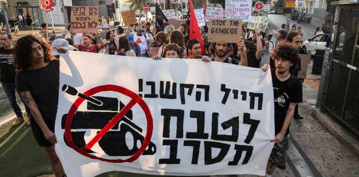 Activistas israelíes de izquierda marchan con pancartas y carteles durante una protesta contra la guerra en Gaza y llaman a rechazar el servicio militar en Tel Aviv.