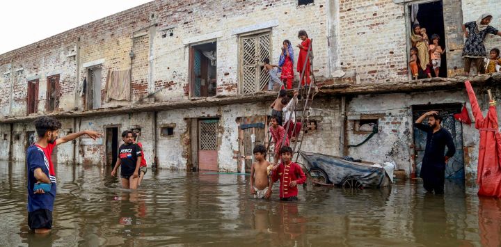 Residentes se reúnen frente a sus casas, sumergidas por las inundaciones tras las fuertes lluvias monzónicas en Hyderabad, provincia de Sindh. Las lluvias monzónicas en Pakistán se han relacionado con más de 110 muertes, incluidas decenas de niños, desde su llegada a finales de junio, según cifras gubernamentales.