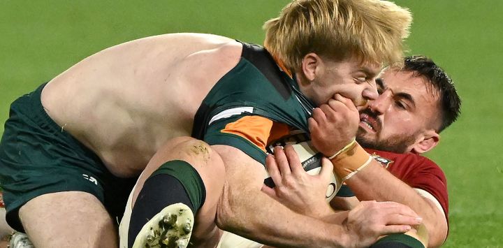 Ronan Kelleher (der.) de los British and Irish Lions tacklea a Harry McLaughlin-Phillips de Australia and New Zealand Invitational XV durante un partido de la gira.