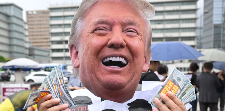 Un miembro de un grupo cívico con una máscara del presidente estadounidense Donald Trump se presenta durante una protesta contra la política arancelaria de Trump cerca de la embajada de Estados Unidos en Seúl.