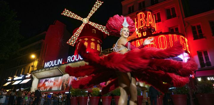 Una bailarina del Moulin Rouge baila bajo las nuevas aspas del Molino de Viento del Moulin Rouge para celebrar su regreso a la actividad en París. Catorce meses después de su caída, las alas del Moulin Rouge han sido reinstaladas y vuelven a moverse, reviviendo una tradición de más de 135 años. Con más de doce metros de diámetro, las alas, que se han convertido en una atracción turística parisina, ahora funcionan con un motor eléctrico hecho a medida para el cabaret parisino.