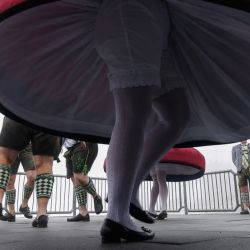 El canciller alemán Friedrich Merz (der.) y el primer ministro del estado federado de Baviera, Markus Soeder (2.º der. oculto), observan a los bailarines tradicionales bávaros "Schuhplattler" en la cima del Zugspitze, en Grainau, cerca de Garmisch-Partenkirchen, en el sur de Alemania, antes de participar en una reunión del gabinete estatal bávaro. | Foto:Michaela Stache / AFP
