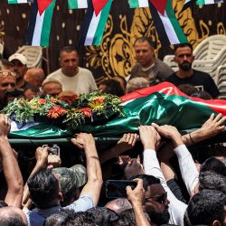 Los dolientes cargan el cuerpo del palestino Mohammad al-Shalabi durante su funeral en la aldea palestina de Al-Mazraa Al-Sharqiya, en la Cisjordania ocupada, tras ser asesinado, según informes, por colonos israelíes. | Foto:ZAIN JAAFAR / AFP