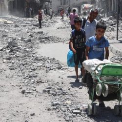 Palestinos buscan objetos para rescatar entre los escombros de los edificios destruidos un día antes en los ataques israelíes contra el barrio de Al-Daraj en la ciudad de Gaza. | Foto:OMAR AL-QATTAA / AFP