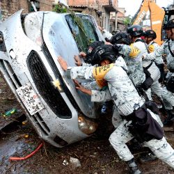 Soldados del ejército revierten un vehículo dañado por las inundaciones repentinas causadas por las fuertes lluvias en Zapopan, Jalisco, México. | Foto:ULISES RUIZ / AFP