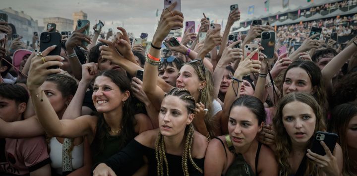 Los asistentes al festival sostienen sus teléfonos móviles mientras se estiran para ver frente al escenario durante la 41.ª edición de las Francofolies de la Rochelle 2025, en La Rochelle, suroeste de Francia.