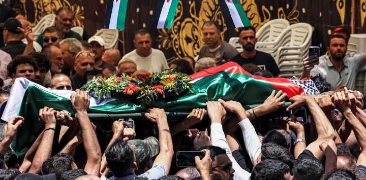 Los dolientes cargan el cuerpo del palestino Mohammad al-Shalabi durante su funeral en la aldea palestina de Al-Mazraa Al-Sharqiya, en la Cisjordania ocupada, tras ser asesinado, según informes, por colonos israelíes.