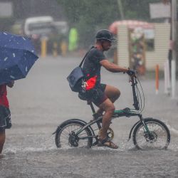 Personas pasan a través de una calle anegada, en Ciudad Quezon, Filipinas. Wipha se intensificó hasta convertirse en una severa tormenta tropical a medida que se alejaba de Filipinas, trayendo fuertes vientos y lluvias torrenciales a muchas áreas. | Foto:Xinhua/Rouelle Umali