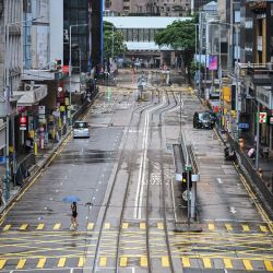 Una mujer cruza una calle vacía en el distrito Central mientras el tifón Wipha avanza hacia Hong Kong. | Foto:PETER PARKS / AFP