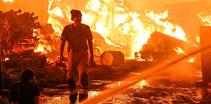 Imagen de bomberos intentando apagar un incendio que envolvió un almacén de madera, en la Gobernación de Jahra, Kuwait.