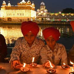 Devotos sijs encienden lámparas de barro en el Templo Dorado iluminado para conmemorar el aniversario del nacimiento del gurú sij Harkrishan Sahib en Amritsar, India. | Foto:Narinder Nanu / AFP
