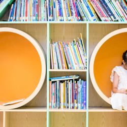 Una niña lee un libro en un centro de servicios comunitarios, en el distrito de Shangcheng de la ciudad de Hangzhou, en la provincia de Zhejiang, en el este de China. Los centros de servicios comunitarios en Hangzhou brindan asistencia con el cuidado de niños y diversas actividades para enriquecer las vacaciones de verano de los niños. | Foto:Xinhua/Jiang Han