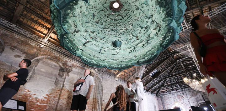 Imagen de visitantes observando una exposición titulada "Vault of Heaven" en el Pabellón Nacional de China de la 19ª Exposición Internacional de Arquitectura de la Bienal de Venecia, en Venecia, Italia.