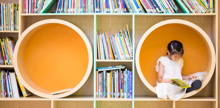 Una niña lee un libro en un centro de servicios comunitarios, en el distrito de Shangcheng de la ciudad de Hangzhou, en la provincia de Zhejiang, en el este de China. Los centros de servicios comunitarios en Hangzhou brindan asistencia con el cuidado de niños y diversas actividades para enriquecer las vacaciones de verano de los niños.