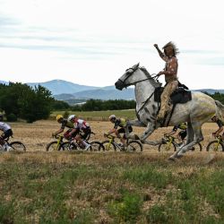 Un hombre a caballo cabalga junto al pelotón durante la 17.ª etapa de la 112.ª edición del Tour de Francia, una carrera ciclista de 160,4 km entre Bolléne y Valence, en el sur de Francia. | Foto:LOIC VENANCE / AFP