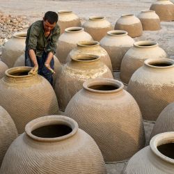 Un hombre afgano prepara hornos de barro, llamados localmente tandoors, tradicionalmente utilizados para hornear naan o pan, en Mazar-i-Sharif. | Foto:Atif Aryan / AFP