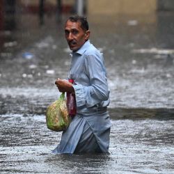 Un hombre camina por una calle inundada durante las fuertes lluvias monzónicas en Rawalpindi. Las lluvias monzónicas en Pakistán se han relacionado con más de 110 muertes, incluidas decenas de niños, desde su llegada a finales de junio, según cifras gubernamentales. | Foto:AAMIR QURESHI / AFP