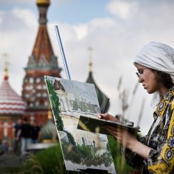 Una niña pinta frente a la Torre Spasskaya del Kremlin y la Catedral de San Basilio en el centro de Moscú, Rusia. | Foto:Alexander Nemenov / AFP
