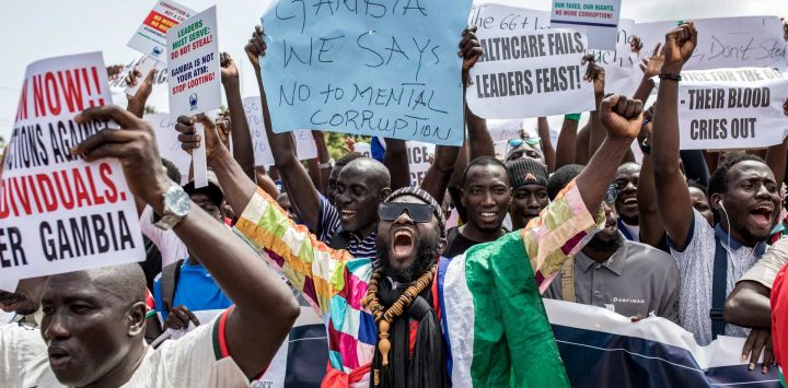 Manifestantes portan pancartas y corean consignas durante una manifestación para exigir transparencia y rendición de cuentas a los líderes gubernamentales, organizada por Gambianos Contra los Bienes Saqueados (GALA), en Banjul.