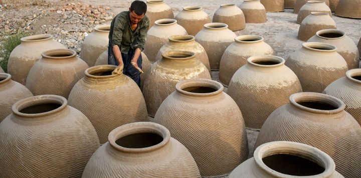 Un hombre afgano prepara hornos de barro, llamados localmente tandoors, tradicionalmente utilizados para hornear naan o pan, en Mazar-i-Sharif.
