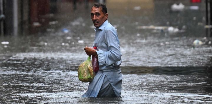 Un hombre camina por una calle inundada durante las fuertes lluvias monzónicas en Rawalpindi. Las lluvias monzónicas en Pakistán se han relacionado con más de 110 muertes, incluidas decenas de niños, desde su llegada a finales de junio, según cifras gubernamentales.