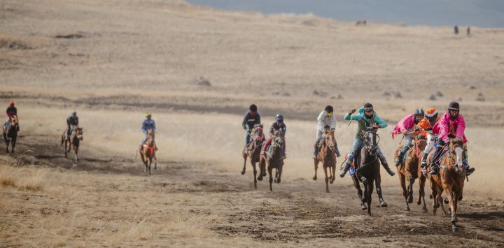 Los jinetes corren hacia la meta durante el evento anual de carreras de caballos que se celebra después del cumpleaños del rey Letsie III en Semonkong, Lesoto.
