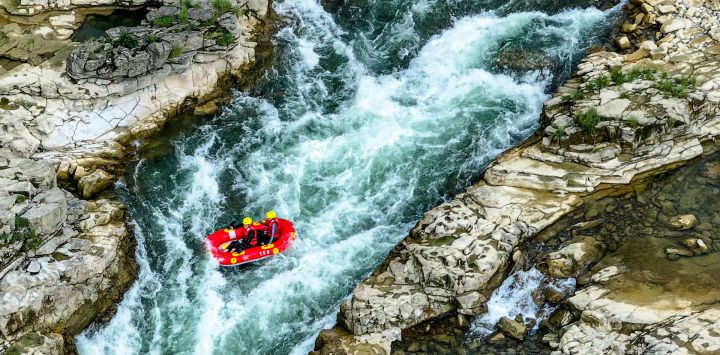 Vista aérea tomada con un dron de personas practicando rafting en un bote inflable en el río Luobei, en el distrito de Guiding, en la provincia de Guizhou, en el suroeste de China.