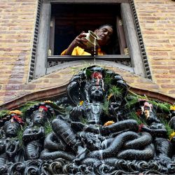 Un devoto vierte leche sobre una estatua de la diosa hindú de las serpientes 'Manasa' con motivo del festival Naga Panchami, cerca de Nagpokhari (estanque de serpientes) en Bhaktapur, en las afueras de Katmandú, Nepal. | Foto:PRAKASH MATHEMA / AFP