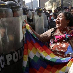 Un manifestante grita frente a la policía antidisturbios durante una protesta contra el gobierno de la presidenta Dina Boluarte en Lima, Perú. | Foto:CONNIE FRANCE / AFP