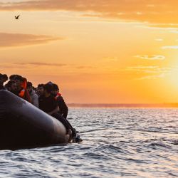 Un migrante intenta subir a la lancha inflable de un contrabandista para intentar cruzar el Canal de la Mancha frente a la playa de Gravelines, en el norte de Francia. | Foto:SAMEER Al-DOUMY / AFP